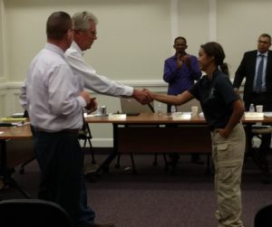 WUHS student Addy Lopez shakes hands with community member Ben Franzich.