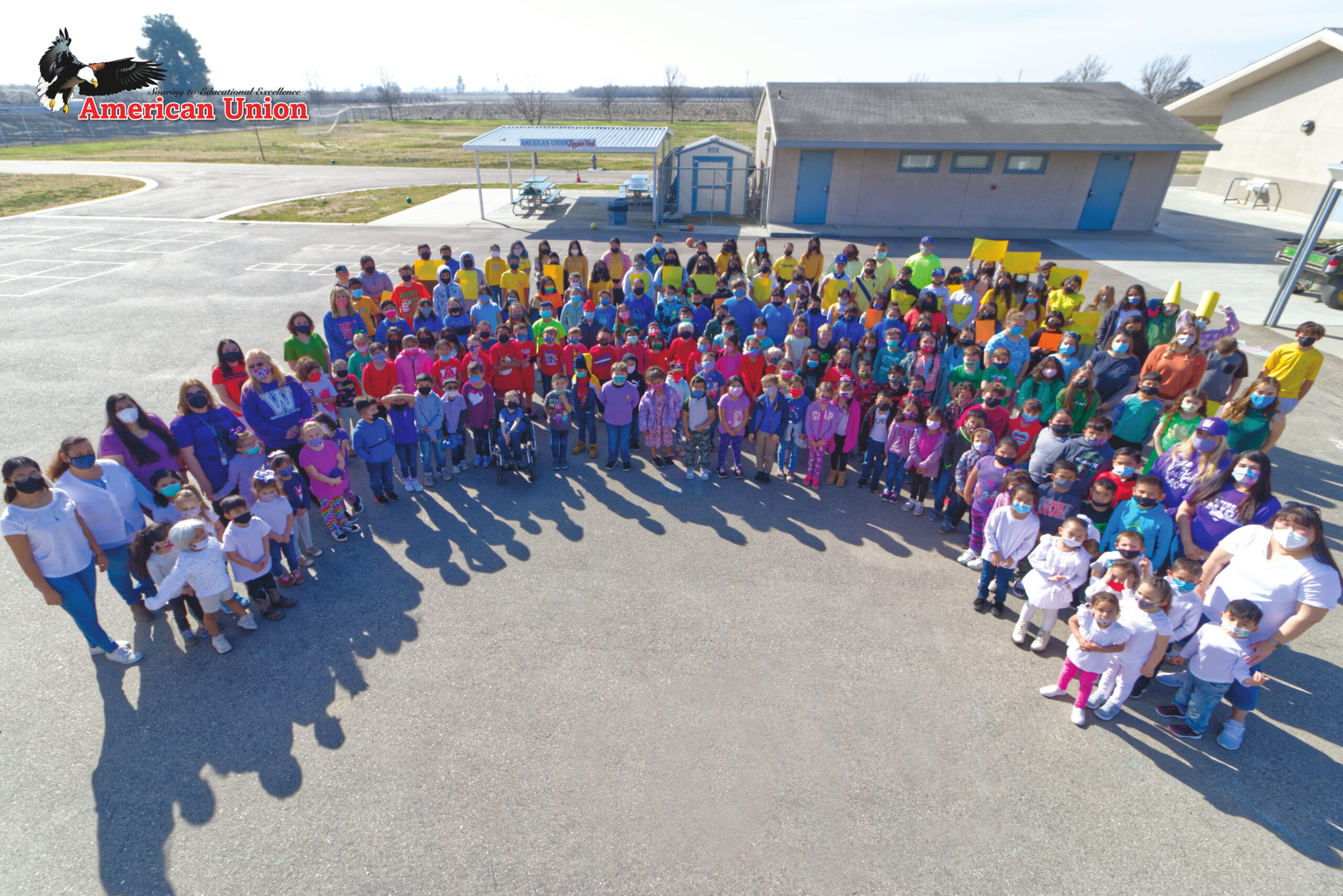 Picture of American Union students Preschool to 2nd grade making a rainbow